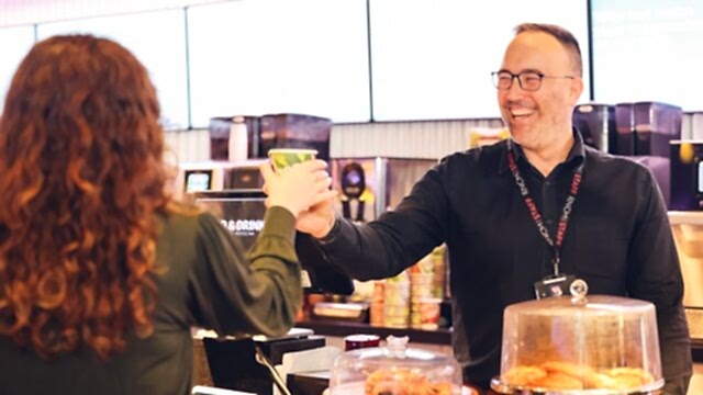A man serving coffee in the RNCM cafe