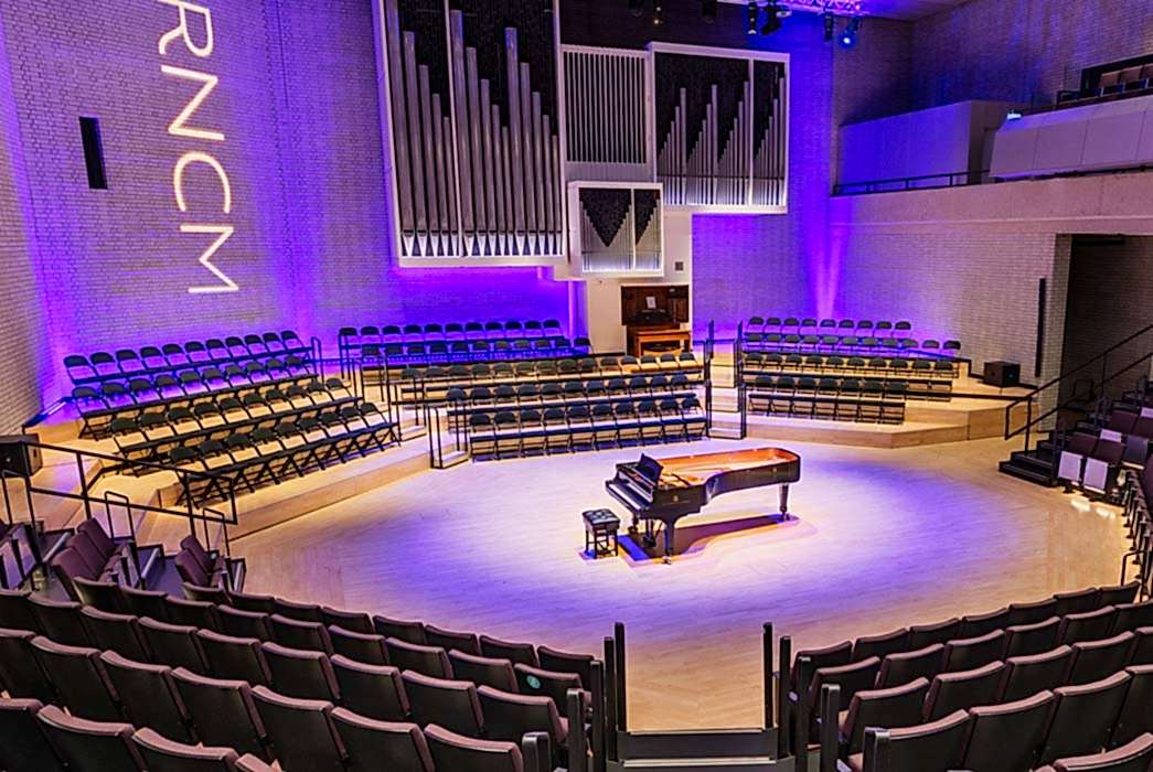 A piano stands in the middle of the stage in the RNCM theatre.